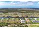 Panoramic aerial view of homes along a canal, set against a backdrop of lush greenery and water at 237 W Pine Valley Ln, Rotonda West, FL 33947