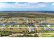 Overhead view of a vibrant community, homes nestled along a waterway amidst lush greenery and open skies at 237 W Pine Valley Ln, Rotonda West, FL 33947