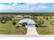 Expansive aerial view of a modern home surrounded by lush greenery and neighboring homes at 237 W Pine Valley Ln, Rotonda West, FL 33947