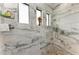 A modern shower with marble walls, dual shower heads, and bright windows at 237 W Pine Valley Ln, Rotonda West, FL 33947