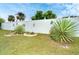 Landscaped backyard featuring a white fence adorned with decorative pieces and succulent-style plants at 2948 Briant St, North Port, FL 34287