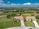 Aerial view of a well-maintained home with a spacious yard, situated on a golf course with lush greenery at 42 Medalist Ln, Rotonda West, FL 33947