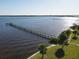 Aerial view of a long dock extending into the tranquil water with lush green shoreline at 4410 Warren Ave # 110, Port Charlotte, FL 33953