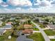 Aerial view of a quiet residential neighborhood with tree-lined streets and various single-Gathering homes at 7084 Tuxedo St, Englewood, FL 34224