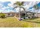 Inviting backyard featuring a screened pool, verdant landscaping, and elegant palm trees at 7084 Tuxedo St, Englewood, FL 34224