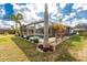 Beautiful backyard oasis featuring a screened pool, lush landscaping, and palm trees for privacy at 7084 Tuxedo St, Englewood, FL 34224