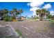 Spacious front yard featuring tropical palm trees and colorful outdoor seating area at 8171 Archie St, Englewood, FL 34224