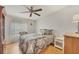 Cozy bedroom with hardwood floors, a ceiling fan, and a large window with sheer curtains at 8436 Buttonquail Dr, Englewood, FL 34224