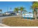 Exterior shot of the Lakeside Club with a sign and palm trees at 8436 Buttonquail Dr, Englewood, FL 34224
