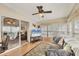 Cozy living room featuring a ceiling fan, television, and sliding glass door to Florida room at 8436 Buttonquail Dr, Englewood, FL 34224