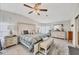 A bright and airy bedroom features neutral walls, wood floors, a ceiling fan, and a large bed at 8436 Buttonquail Dr, Englewood, FL 34224
