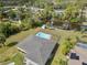 Aerial view of a home with a private pool and canal access, surrounded by lush greenery and trees at 975 Clearview Dr, Port Charlotte, FL 33953