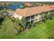 An elevated view showing a two-story condo with private screened balconies overlooking a spacious lawn at 10063 Crooked Creek Dr # 103, Venice, FL 34293