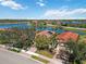 Aerial view of houses with red tile roofs, lake views, and screened patios at 10508 Crooked Creek Dr, Venice, FL 34293
