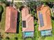 Aerial view featuring houses with red tile roofs, screened pools, and neat landscaping at 10508 Crooked Creek Dr, Venice, FL 34293