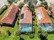 A top-down aerial view of three homes featuring screened in pools and tile roofs at 10508 Crooked Creek Dr, Venice, FL 34293