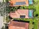 Aerial view of a home with a terracotta roof, solar panels, screened-in pool, and well-maintained landscaping at 10508 Crooked Creek Dr, Venice, FL 34293