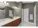 Contemporary bathroom featuring a dual sink vanity, updated lighting, and private toilet room at 10508 Crooked Creek Dr, Venice, FL 34293
