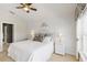 Bright bedroom with white furniture, ceiling fan, and ensuite bathroom through doorway at 10508 Crooked Creek Dr, Venice, FL 34293