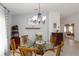 A dining room features a glass table, 6 chairs, a chandelier and decorations on the walls at 10508 Crooked Creek Dr, Venice, FL 34293