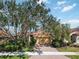 Inviting home featuring a well-manicured lawn and mature trees at 10508 Crooked Creek Dr, Venice, FL 34293