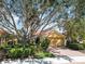 Beautiful home with lush landscaping, mature trees, and a brick driveway at 10508 Crooked Creek Dr, Venice, FL 34293