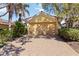 Exterior view of a home with a two-car garage, terracotta roof, and a brick driveway at 10508 Crooked Creek Dr, Venice, FL 34293