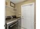 Well-equipped laundry room with modern washer and dryer, storage shelves, and convenient access door at 10508 Crooked Creek Dr, Venice, FL 34293