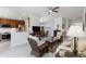 Open living room view of kitchen, dining room with ceiling fan, and wicker furniture at 10508 Crooked Creek Dr, Venice, FL 34293