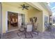 Inviting outdoor patio with a ceiling fan, table, chairs, and sliding doors leading to the living area at 10508 Crooked Creek Dr, Venice, FL 34293