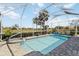View of a screened pool featuring a hot tub and covered with blue rolled-up solar cover at 10508 Crooked Creek Dr, Venice, FL 34293