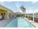 An in-ground screened pool offers lake views, set in a brick-paved pool deck with privacy landscaping at 10508 Crooked Creek Dr, Venice, FL 34293