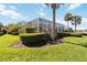 Landscaped backyard featuring a screened-in patio and lush green lawn at 10508 Crooked Creek Dr, Venice, FL 34293