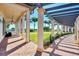 Covered walkway featuring brick pavers, decorative columns, and a pergola with views of the green landscaping and clear blue sky at 10508 Crooked Creek Dr, Venice, FL 34293