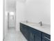 Modern bathroom with dual vanity, quartz countertops, navy blue cabinets, patterned tile floors, and natural light at 10688 Mcalester Cir, Port Charlotte, FL 33981
