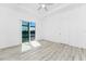 A bedroom with wood-look floors, bright natural light, a ceiling fan and access to the lanai at 10688 Mcalester Cir, Port Charlotte, FL 33981