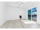 A bright bedroom featuring wood-look floors, a ceiling fan and glass doors leading to a screened lanai at 10688 Mcalester Cir, Port Charlotte, FL 33981