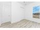 A bright bedroom features wood floors, a window overlooking several trucks, and a closet with a sliding door at 10688 Mcalester Cir, Port Charlotte, FL 33981