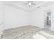 Bright bedroom featuring wood-look floors, bright natural light, and an adjoining bathroom with patterned floors at 10688 Mcalester Cir, Port Charlotte, FL 33981
