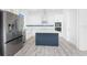 Bright kitchen featuring white cabinetry, stainless steel appliances, and a stylish blue island at 10688 Mcalester Cir, Port Charlotte, FL 33981