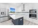 Modern kitchen with white cabinets, stainless steel appliances, island, and natural light from window at 10688 Mcalester Cir, Port Charlotte, FL 33981