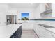 A bright kitchen boasting stainless steel appliances and sleek white cabinetry with a blue backsplash at 10688 Mcalester Cir, Port Charlotte, FL 33981