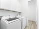 Convenient laundry room with modern washer and dryer units and ample storage cabinets at 10688 Mcalester Cir, Port Charlotte, FL 33981