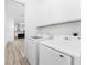 Laundry room with new washer and dryer, built-in cabinets, and convenient access to the kitchen at 10688 Mcalester Cir, Port Charlotte, FL 33981