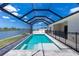 Sparkling pool with a safety fence and waterfront views, under a screened enclosure at 10688 Mcalester Cir, Port Charlotte, FL 33981