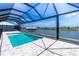 Screened-in pool area overlooking the water features a modern pool and scenic views at 10688 Mcalester Cir, Port Charlotte, FL 33981