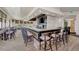 View of the bar area with high-top seating, a fully stocked bar, a TV, and views of the dining area and outdoor scenery at 10953 Bullrush Dr, Venice, FL 34293