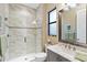 Elegant bathroom with a walk-in shower, marble countertops, and modern fixtures at 10953 Bullrush Dr, Venice, FL 34293