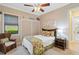 This cozy bedroom boasts a ceiling fan, natural light, and decorative leaf artwork for a peaceful ambiance at 10953 Bullrush Dr, Venice, FL 34293