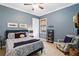 Comfortable bedroom with blue accent wall, patterned bedding, and a cozy reading nook near the window at 10953 Bullrush Dr, Venice, FL 34293
